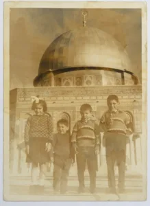 A black and white photo of Omair Da'nah's children at Al-Aqsa Mosque in 1967. shown in the photo; right to left, Salam, Mazin, Nader, and Leena